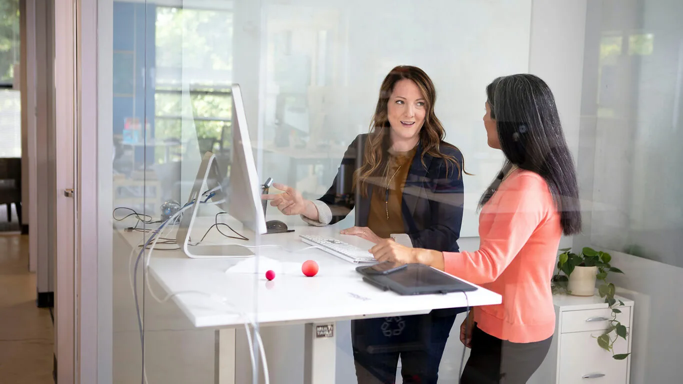image shows a woman explaining how to use a CCMS to another person for technical publications